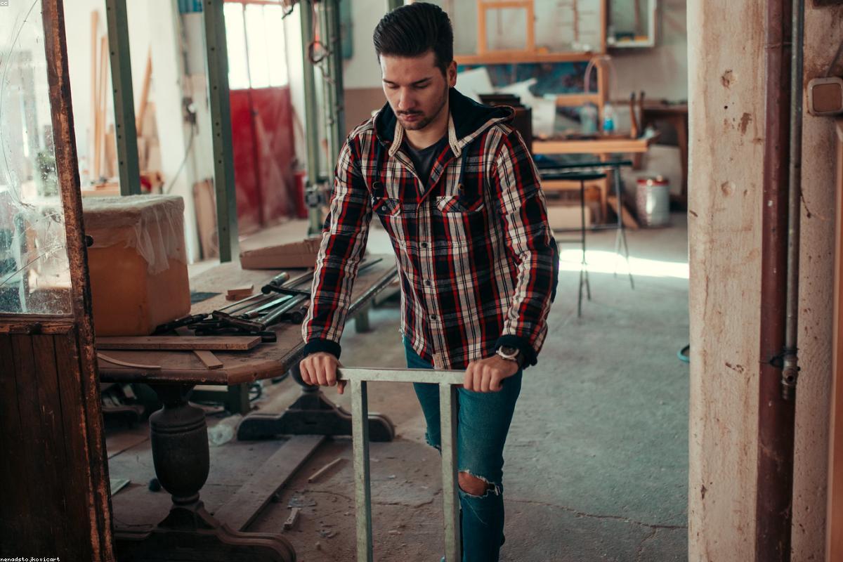 Menuisier assemblant un meuble en bois massif dans son atelier